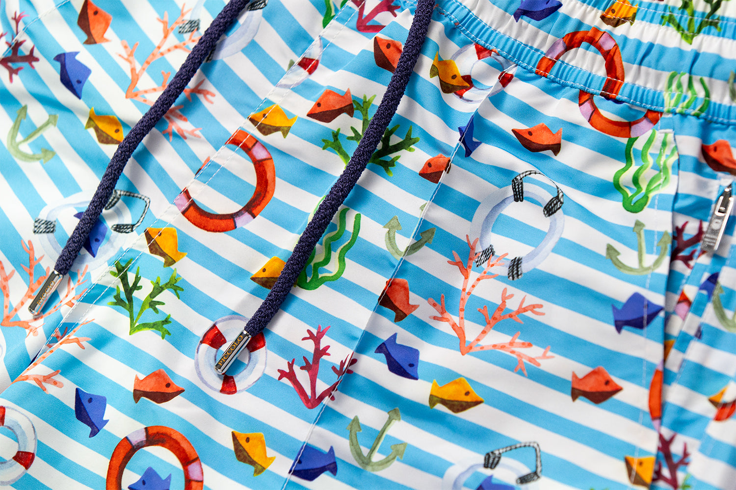 Detail of the KAI nautical motif featuring Mediterranean stripes, lifebuoys and marine elements, with signature front seam and drawstring craftsmanship by Piccolo Riccio.