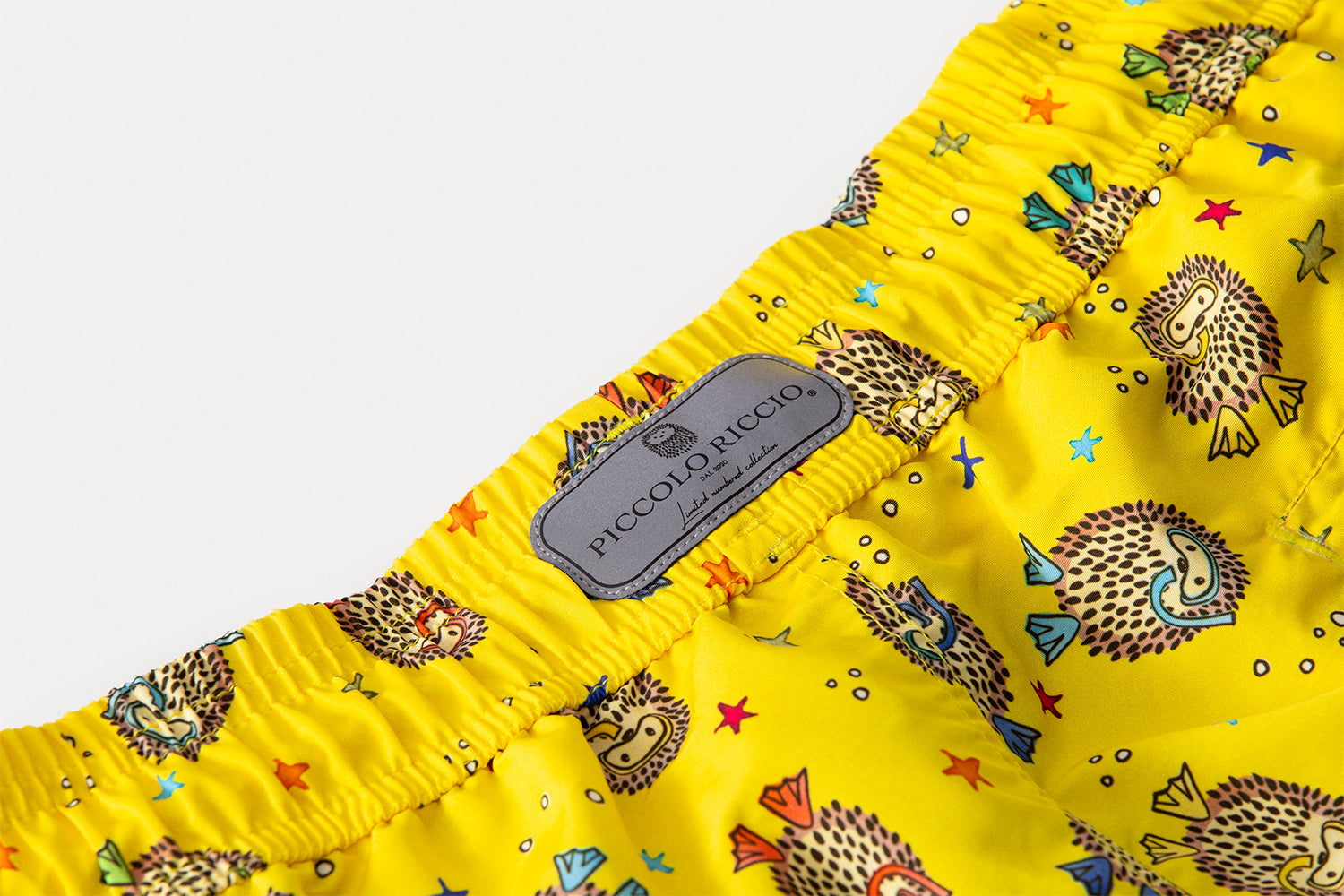 Reflective Limited Number Collection signature label of the YAKUSHIMA flagship luxury swim shorts by Piccolo Riccio.