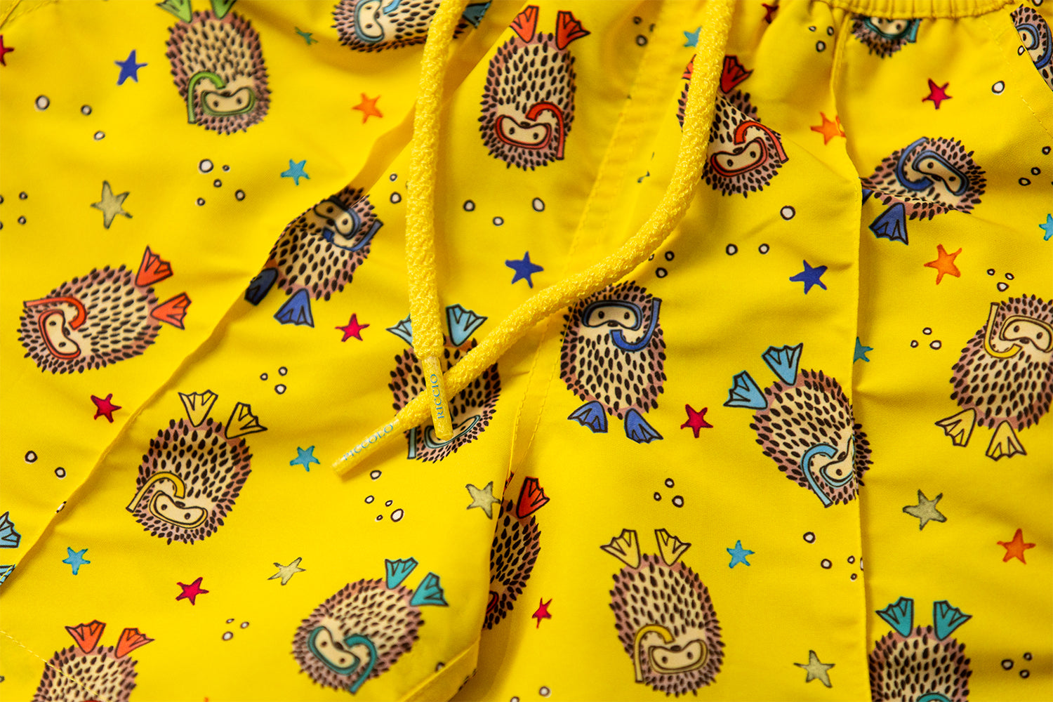 Detail of the YAKUSHIMA signature hedgehog motif, signature front seam and drawstring craftsmanship by Piccolo Riccio.
