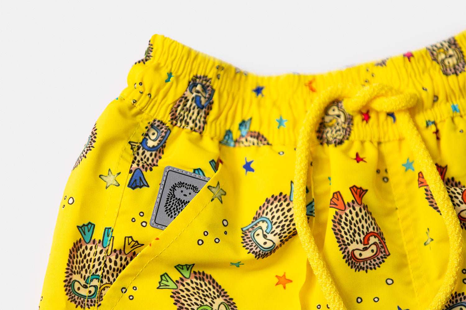 Detail of the discreetly integrated Piccolo Riccio signature within the front pocket of the YAKUSHIMA Children's Edition.